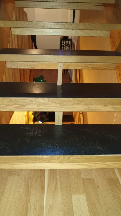 Trästege sett underifrån som visar stegens undersida och sidostycken.