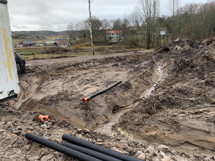 Nygrävda diken för dränering med markduk och dräneringsrör på en blivande byggplats.