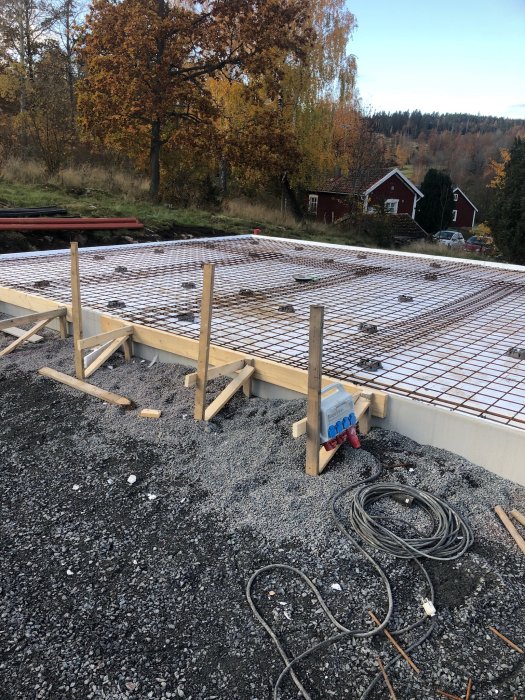 Förberedelse för gjutning av garageplatta med armeringsnät, kantstål och avloppsrör.