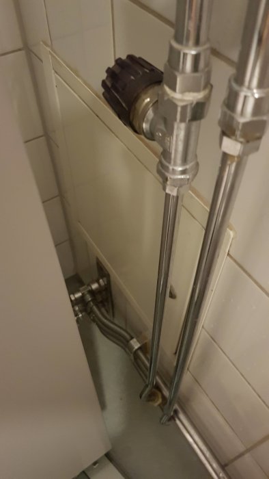 Handdukstork med termostatventil i ett kaklat badrum, verkar inte fungera korrekt.