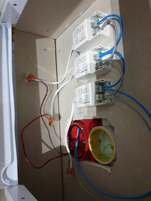 Elektriska drivdon monterade på en vägg med synliga lågspänningskablar och en eluttag.