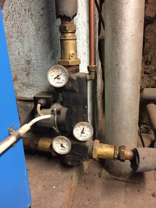 Värmesystem med Nibe Vedex 3000, tre manometrar och kopplingar mot vägg.
