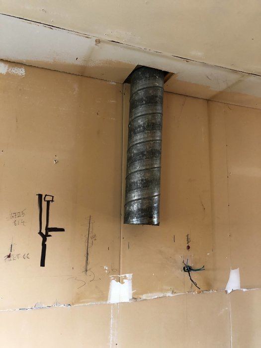 Äldre ventilationssystem med ett metallrör som går från köket upp i taket, före renovering och installation av nytt system.