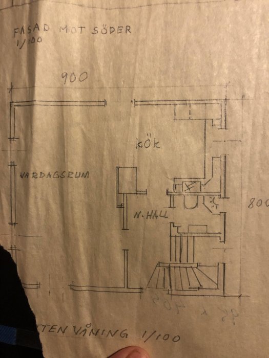 Handritad planritning av ett hus markerad med röd för befintlig vägg och blå för ny tänkt vägg.