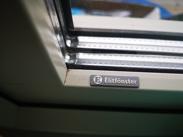 Närbild på ett stängt Elitfönster med logotyp synlig, kolv och ram detaliseras.