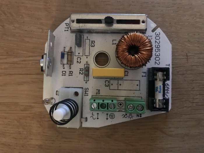 Relco Rondo dimmer för belysning med vridknapp, kopplingsterminaler och spole på en träyta.