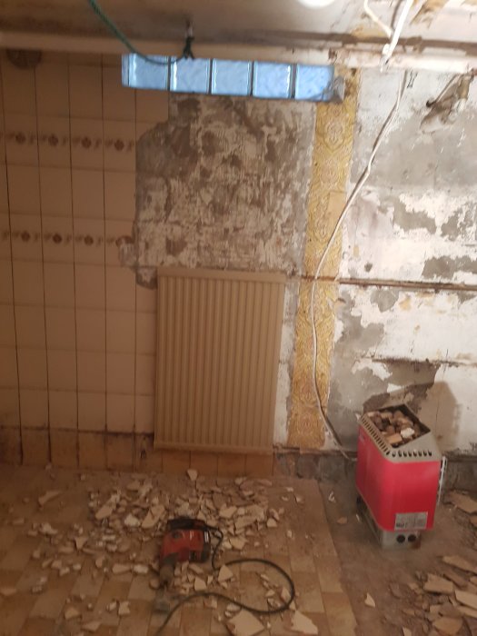 Rivningsarbete i badrum med kakelväggar, rörmokeri och utspridd rivningsrester på golvet.