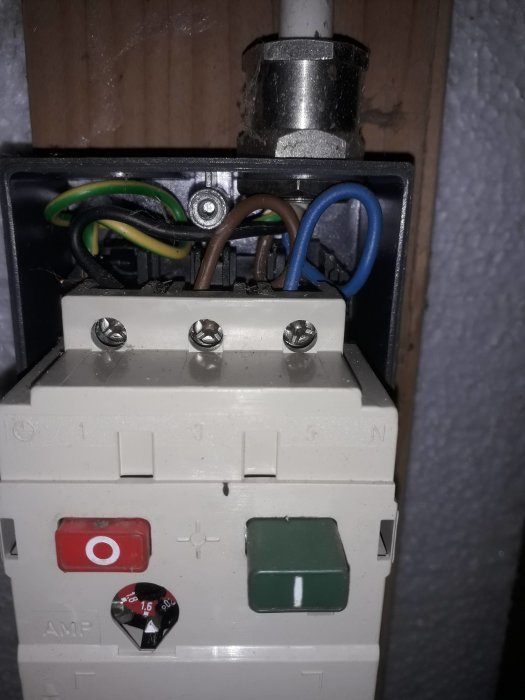 Brytare till gammal hydroforpump med anslutna kablar och intilliggande säkringar.