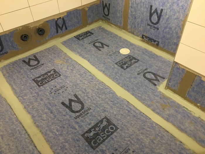 Ett badrumsgolv med nyinstallerat tätskikt och Purus golvbrunn, redo för klinkersättning.