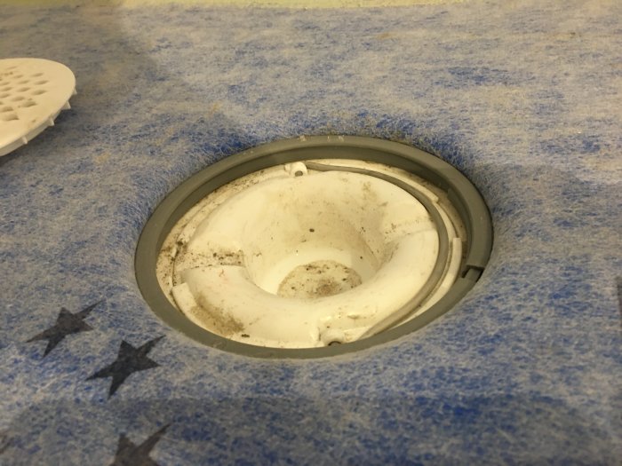 Nylagd tätskikt på golv med Purus golvbrunn, manschett synlig under folie.