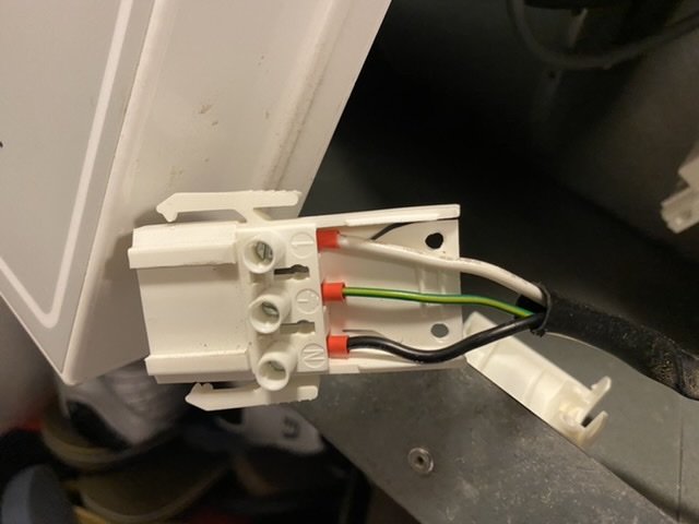 Elkoppling med en blå, brun och grön kabel ansluten till en vit kontakt.