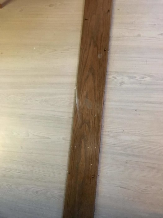 Trälist som övergång mellan två olika golvtyper, 12 cm bred med rundade kanter.