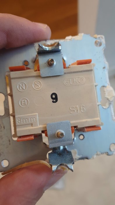 Närbild på en elektrisk installationsdosas insida med ELKO brytare och ledningar.