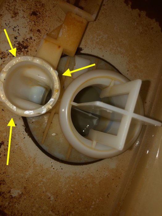 Söndrigt Ifö Cera/Aqua 21 ventilsäte i toalett med synliga brutna plastklor och rostfläckar.