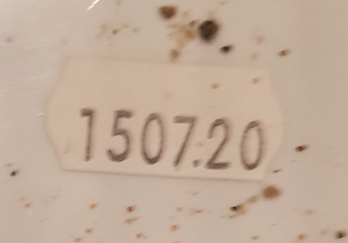 Etikett med siffrorna 150720, möjligt datum eller batchnummer, på en smutsig yta.