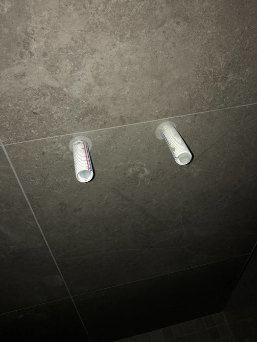Vattenanslutningar som sticker ut från en kaklad badrumsvägg för installation av duschblandare.