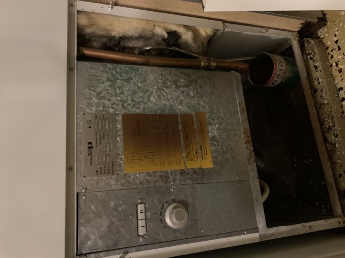 Varmvattenberedare märkt 'Parca Norrhammar M300 VS' med vattenläckage och uppsamlad plåtburk.