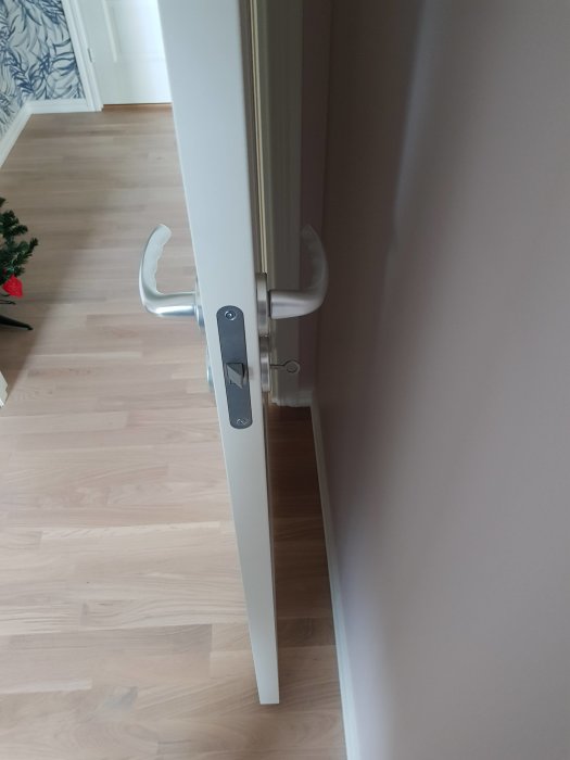 Ljus parkettgolv Shade EK från Tarkett med synlig dörr och dörrhandtag, inhemsk miljö.