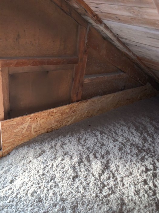Inredning av vind med träbjälkar och isolering, möjlig fråga om bärande vägg för fönsterinstallation.
