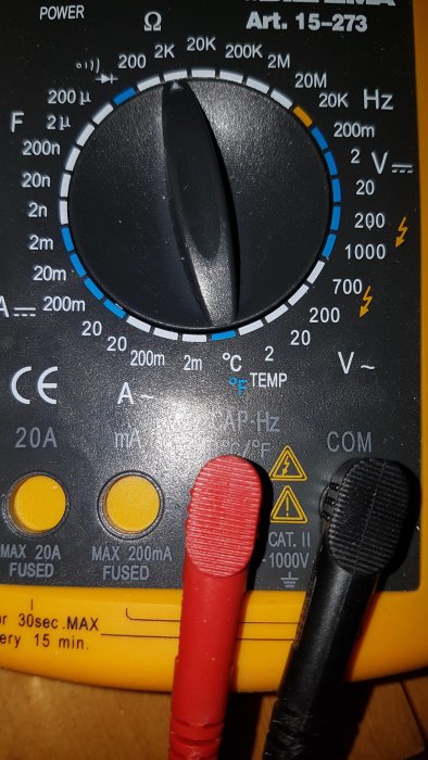 Digital multimeter inställd för mätning, med röd och svart mätprobe.