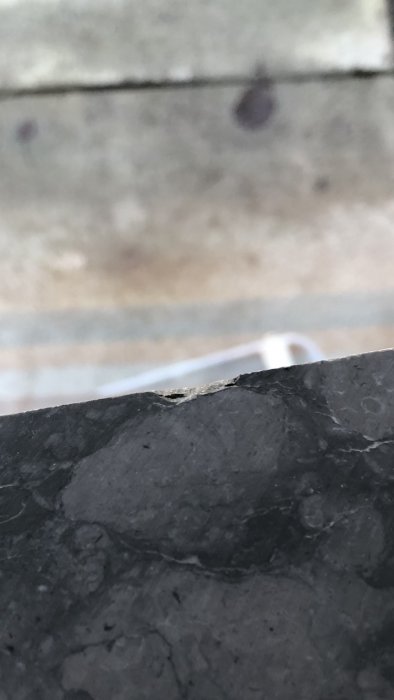 Närbild på material med hack på ovansidan, skador som diskuteras i byggforum.