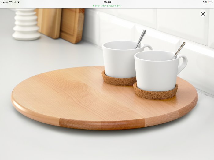 Trärundel "Snudda" snurrbricka med två vita muggar och korkunderlägg på ett köksbord.