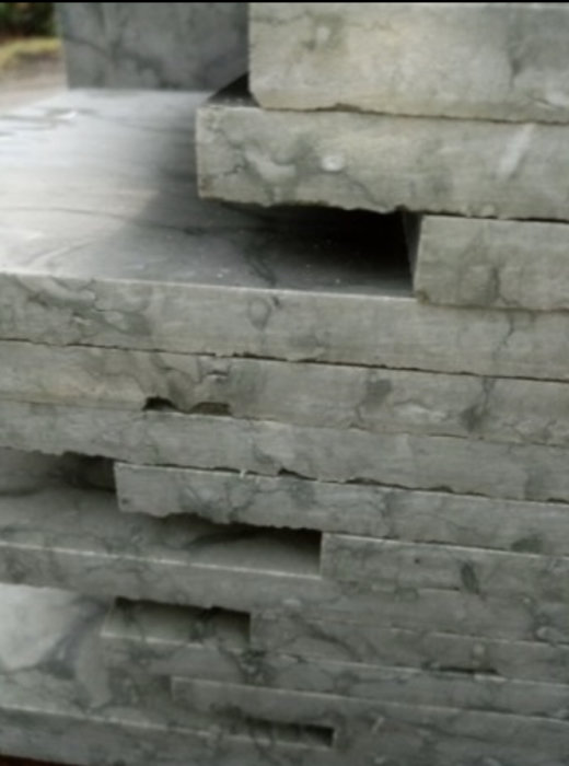 Stapel av stenplattor för inomhusbruk med synliga håligheter och utan skydd mellan lagren.