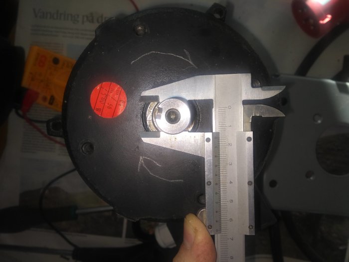 Skjutmått mäter diameter på en motoraxel nära remskivan.