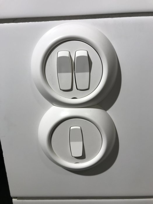 Vit strömbrytare och eluttag på en nyrenoverad vägg