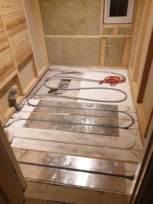 Installation av golvvärme i ett pågående byggprojekt med synliga värmeslingor och isolering.