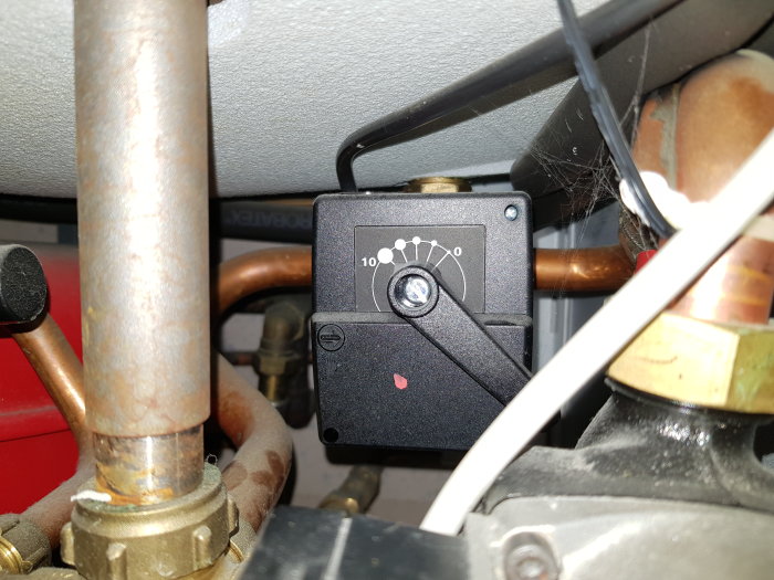 Shuntventil med inställningsratt i fokus ställt på läge 3, omgiven av kopparledningar och spindelnät.