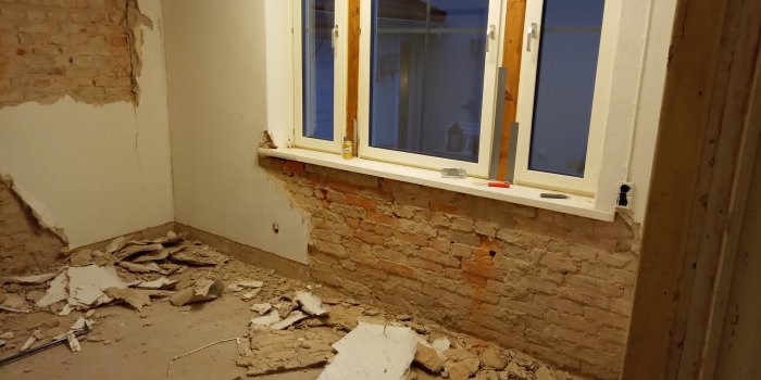 Rivningsarbete i blivande tvättstuga med avskalad puts och synligt tegel vid fönster.