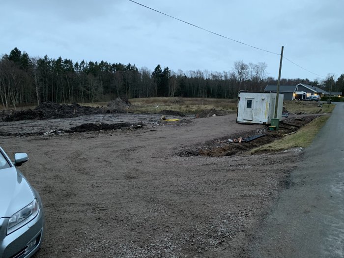 Arbetsbod flyttad av hjullastare till sitt ursprungliga plats med skogen i bakgrunden.