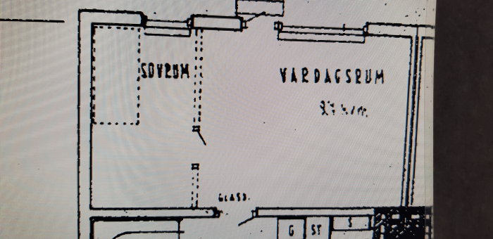 Pohjapiirros kellarista, jossa näkyy betonirakenteinen varasto ja olohuoneen sijainti. Seinät merkitty katkoviivalla.