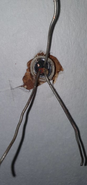 Torra och skadade elektriska kablar utanför en vägg där en strömbrytare tagits bort.