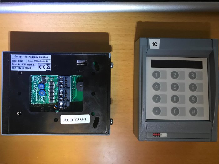 Två enheter varav en öppnad med synligt kretskort, och en stängd säkerhetstangentbord för inmatning av koder.