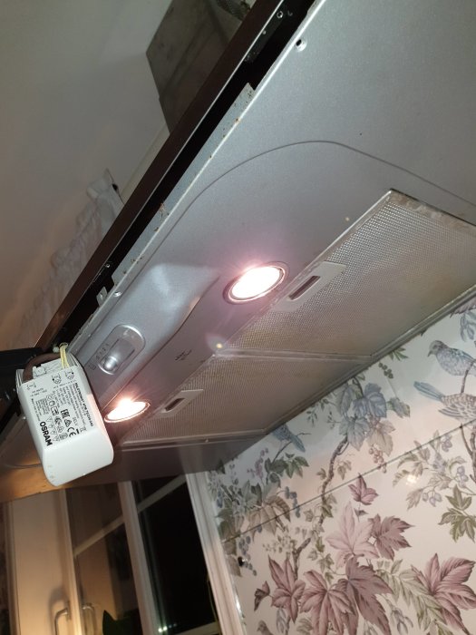 Nyinstallerad transformator hängandes från en köksfläkt med tända spotlights.
