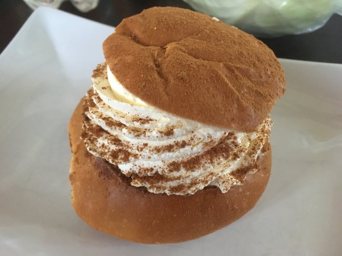 En marängsvissemla med grädde och chokladsås toppad med krossade maränger.