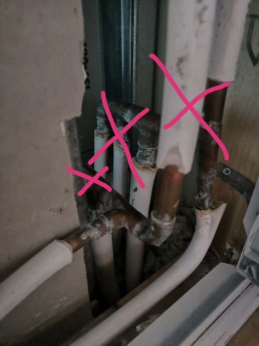 VVS-installation med markerade befintliga kopparledningar och prisolrör inför badrumsrenovering.
