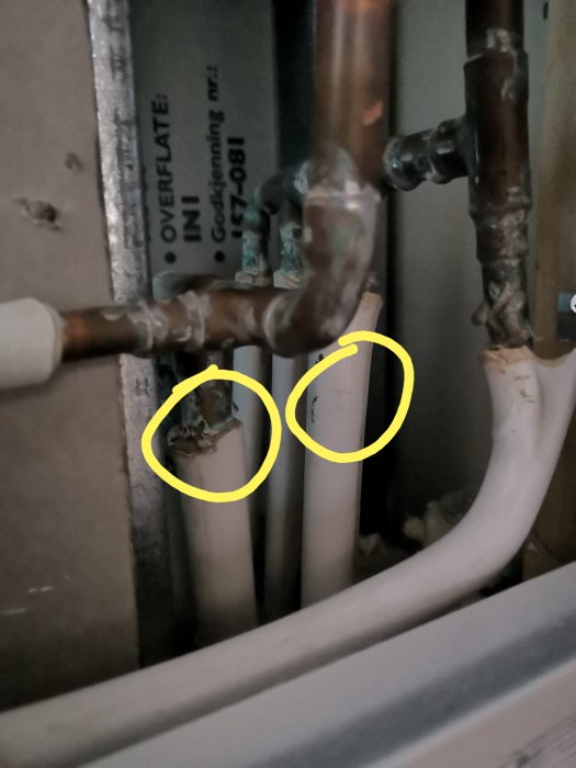 Koppar- och prisolrör markerade med gula cirklar som föreställande delar av VVS-installation i vägg under renovering.