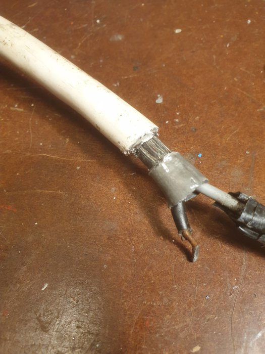 Avgrävd elkabel med synlig ledare, nolla och osäker jordanslutning.