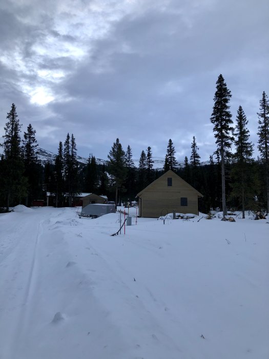 Vinterlandskap med snö, byggnader och träd, troligen plats för nyligen monterade vindavledare.