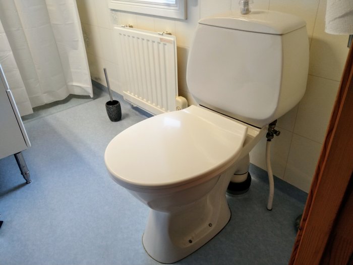 Nyinstallerad vit wc-stol i ett badrum med synliga rör och en oljepanna.