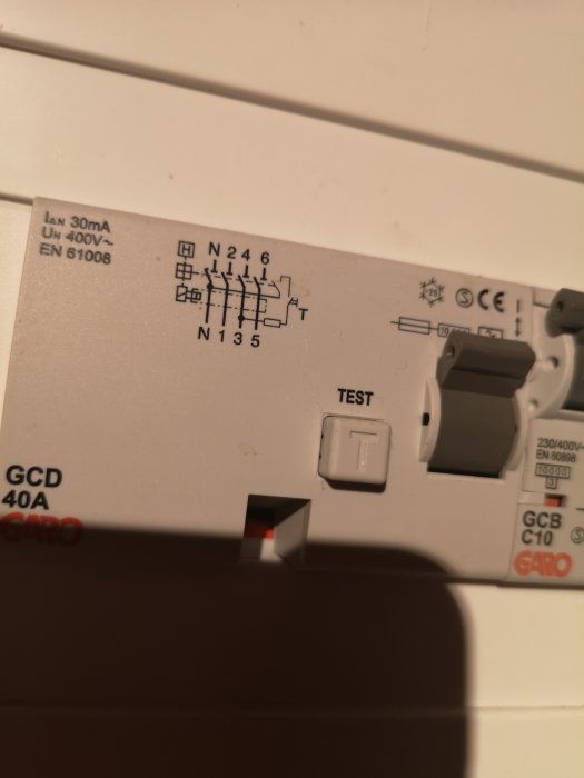 Jordfelsbrytare märkt med "GCD 40A", "GARO", testknapp och tekniska symboler, eventuell koppling till golvvärmen oklar.