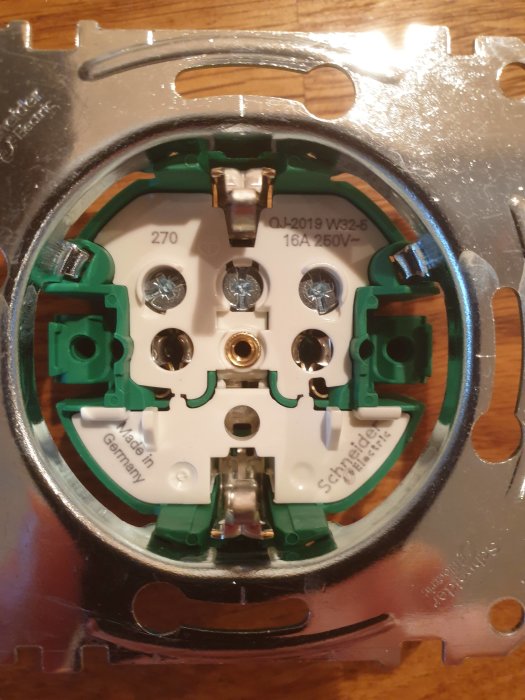 Öppet elektriskt vägguttag utan märkning för fas och nolla, redo för installation.
