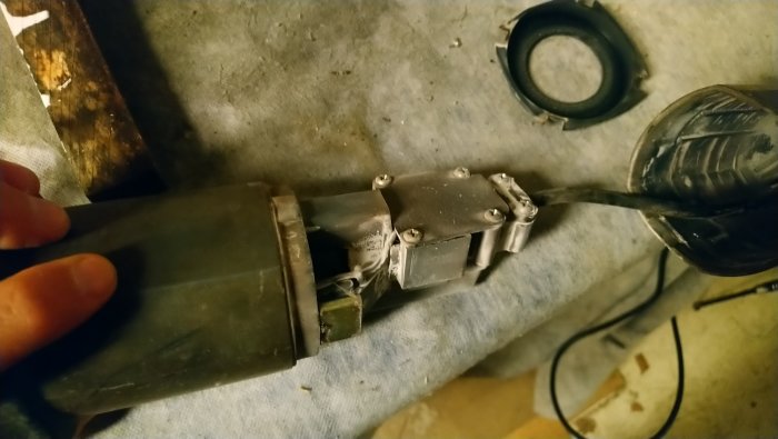 Närbild på uppskruvad elektrisk motor till verktyg, med synliga kolen och kopparfärgade del.