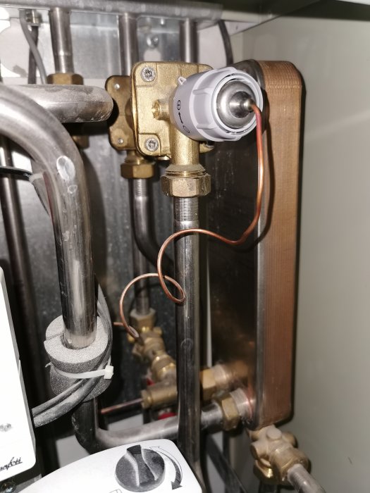 Inre del av värmesystem med termostat, ledningar och blandningsventil.