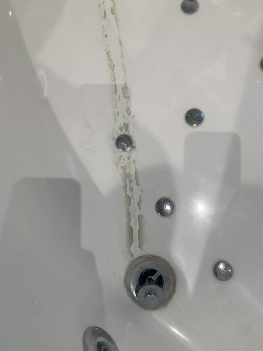 Missfärgning av kalkavlagringar längs kanten på en bubbelpool där en kran har läckt.
