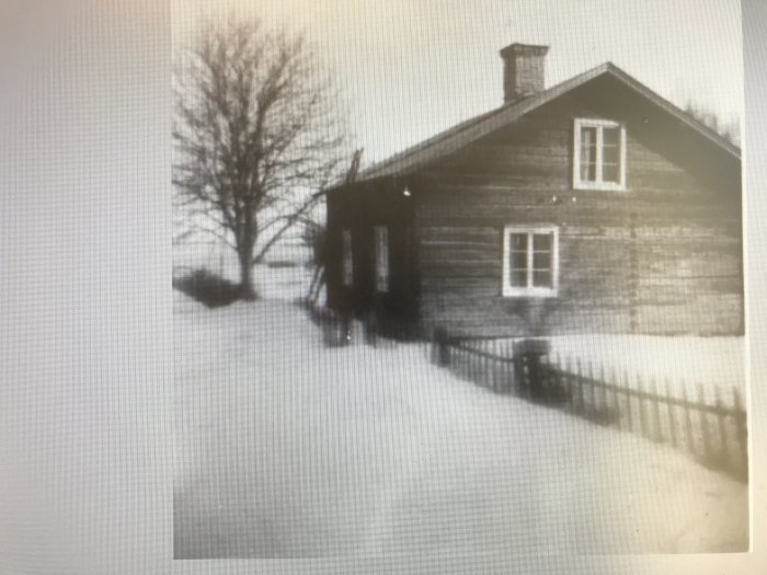 Svartvit bild av ett äldre trähus med snötäckt mark från 1930-talet.