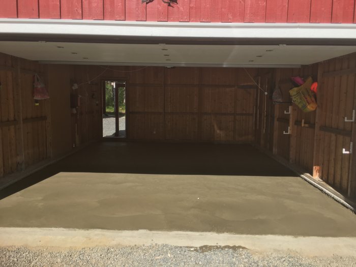 Nyjuten betongplatta i garage med synligt armeringsnät och lecablock längs kanterna.